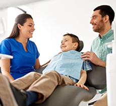 Father and young son speaking to dentist at appointment