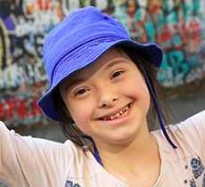Smiling young girl wearing blue hat